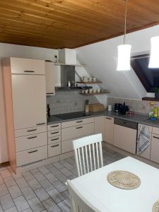 una cucina con armadi bianchi e tavolo bianco di Große Wohnung mit Altstadtnähe 