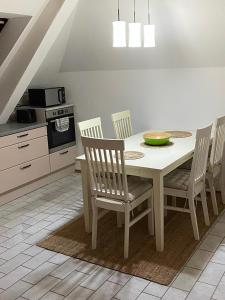 y cocina con mesa blanca, sillas y fogones. en Große Wohnung mit Altstadtnähe, 