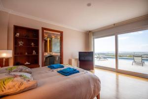 una camera da letto con un letto grande e una grande finestra di Villa Luxueuse, 2 piscines, spa et salle de sport, 5 chambres, 4 salles de bain a Palau-Saverdera Altre 41 foto