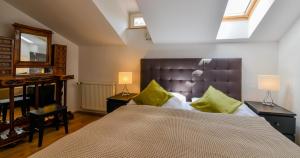 a bedroom with a large bed with green pillows at Apartments Rybná in Prague