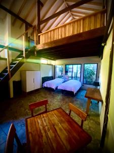 Habitación con 2 camas, mesa y loft. en Hostal Tatul, en Diaguita
