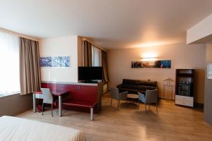 阿爾巴的住宿－Hotel Ristorante I Castelli，酒店客房配有一张床、一张书桌和一张沙发。