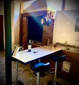 a kitchen with a counter and two bar stools at Hostal Tatul in Diaguita