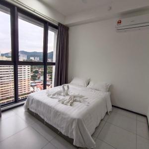 a white bed in a room with a large window at Veneto homestay Urban Suite 3BR with infinity pool in Jelutong