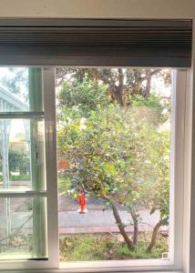 a window with a view of a fire hydrant behind it at Guesthouse near Disney, Walmart with private parking in Santa Ana