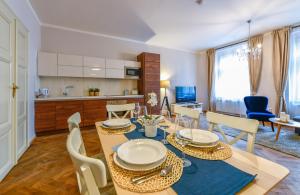 Una cocina y un comedor con mesa y sillas. en Apartments Rybná, en Praga