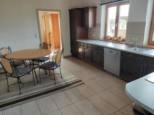 Una cocina con una mesa y sillas y un fregadero. en Ferienwohnung am Metzgerhof, en Bogen