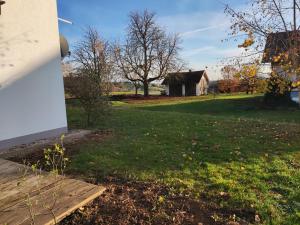 a grassy yard with an old house in the background at Ferienwohnung am Metzgerhof in Bogen