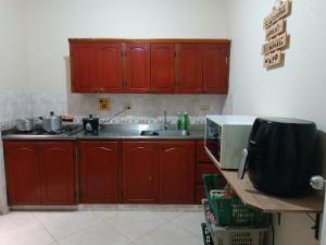 Pa Pasiar Hostal في ميديلين: مطبخ مع دواليب حمراء ومغسلة
