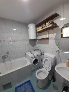a bathroom with a toilet and a tub and a sink at L&L in Sarajevo