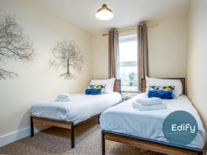 two beds in a room with a window at Spacious House Ideal For Groups in Southampton