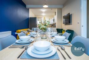 a dining room table with bowls and plates on it at Spacious House Ideal For Groups in Southampton