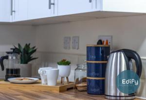 a kitchen counter with a coffee pot on a table at Spacious House Ideal For Groups in Southampton