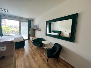 a bedroom with a mirror and a bed and a chair at Entrez Apartments 5 - City center with small garden in Košice