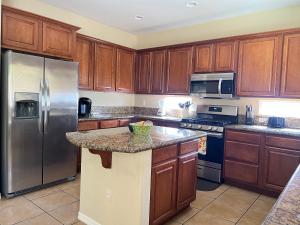 a kitchen with wooden cabinets and stainless steel appliances at Peaceful Oasis 4 bedroom in Summerlin close to Redrock in Las Vegas