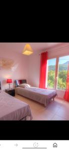 una camera da letto con due letti e una finestra di Villa les MYRTES a Olmeto