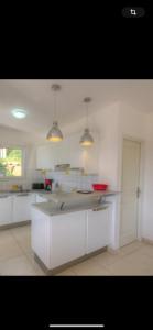 una cucina con mobili bianchi e un piano di lavoro di Villa les MYRTES a Olmeto