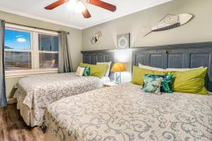 a bedroom with two beds and a ceiling fan at 2-BDRM Across From Beach 10 min Walk to Hangout! in Gulf Shores