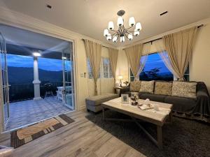 ein Wohnzimmer mit Sofa und Tisch in der Unterkunft Misty English Cottage in Ban Non Na Yao