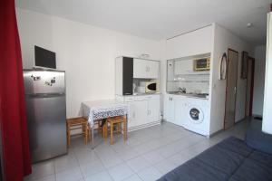 een keuken met een koelkast en een wasmachine bij Studio 4 personnes vue sur la Marina in Canet-en-Roussillon