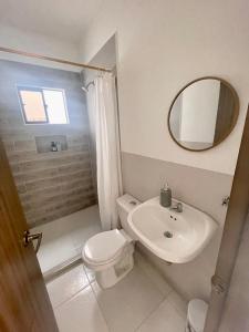 y baño con aseo, lavabo y espejo. en Apartamento 202 Entero, en Montería