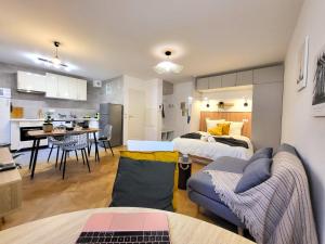 a living room with two beds and a kitchen at Le Monumental in Le Plessis-Robinson