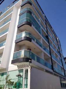 a building with balconies on the side of it at Apartamento super novo, ótima localização na praia do Recreio! in Rio de Janeiro