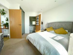 a bedroom with a large bed with yellow pillows at Luxury One-Bedroom Apartment with a View - Barking in London