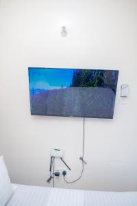 a flat screen tv hanging on a white wall at The Nest Studio Apartment in Bamburi Mombasa in Mombasa