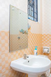 a bathroom with a sink and a mirror at The Nest Studio Apartment in Bamburi Mombasa in Mombasa