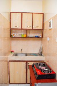 a small kitchen with a stove and a sink at The Nest Studio Apartment in Bamburi Mombasa in Mombasa