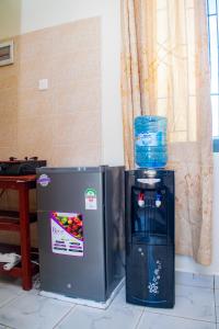 a refrigerator and a water dispenser next to a window at The Nest Studio Apartment in Bamburi Mombasa in Mombasa