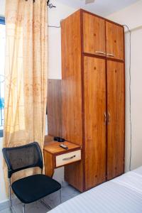 a bedroom with a bed and a desk and a chair at The Nest Studio Apartment in Bamburi Mombasa in Mombasa