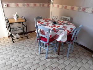 uma mesa de jantar com uma toalha de mesa vermelha e branca em Villa Récompense Côte Atlantique n3 em Soulac-sur-Mer