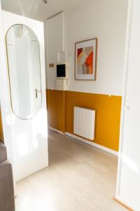 un salon avec un mur jaune et blanc dans l'établissement Le Yellow Vibe - Parking privé gratuit, proche Chantilly, Wifi haut débit, idéal télétravail, à Cires-lès-Mello