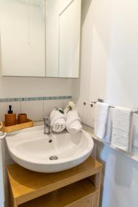 La salle de bains est pourvue d'un lavabo, d'un miroir et de serviettes. dans l'établissement Le Yellow Vibe - Parking privé gratuit, proche Chantilly, Wifi haut débit, idéal télétravail, à Cires-lès-Mello