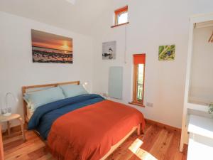 1 dormitorio con 1 cama con manta naranja en Easter Blervie, en Forres