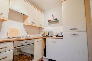 a kitchen with white cabinets and a white refrigerator at Guest Homes - Blackthorn Retreat in Red Lodge