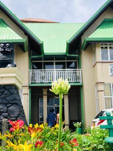 a house with a flower in front of it at Gregory's Bungalow in Nuwara Eliya