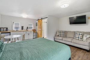 a bedroom with a bed and a couch and a kitchen at Selkirk Motel in Colville