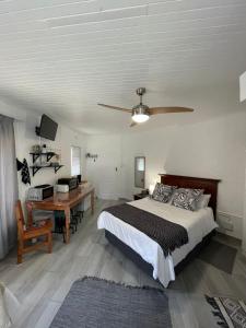 um quarto com uma cama, uma secretária e uma ventoinha de tecto em Groenewald's Haven em Nelspruit