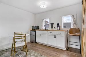 a kitchen with white cabinets and a counter and chairs at Selkirk Motel in Colville