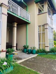 a house with potted plants in front of it at Gregory's Bungalow in Nuwara Eliya