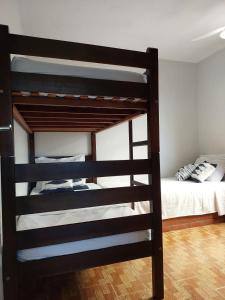 a black bunk bed in a room with a bed at MIRANTE DA PRAINHA in Arraial do Cabo