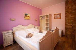 Un dormitorio con una cama blanca con zapatillas. en Penzion Anebel en Luhačovice