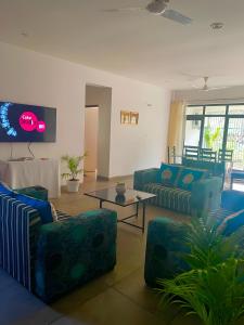 Sal Woods في دهرادون: غرفة معيشة مع أرائك زرقاء وتلفزيون