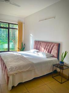 Sal Woods في دهرادون: غرفة نوم مع سرير كبير مع اللوح الأمامي وردي