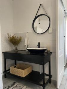 La salle de bains est pourvue d'un lavabo noir et d'un miroir. dans l'établissement Groenewald's Haven, à Nelspruit