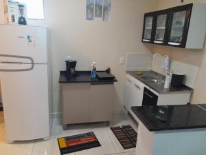 uma pequena cozinha com um frigorífico e um lavatório em Hospedagem do Elias em Cuiabá