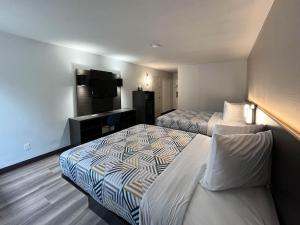 Habitación de hotel con 2 camas y TV de pantalla plana. en Motel 6 Nacogdoches TX SFA University, en Nacogdoches